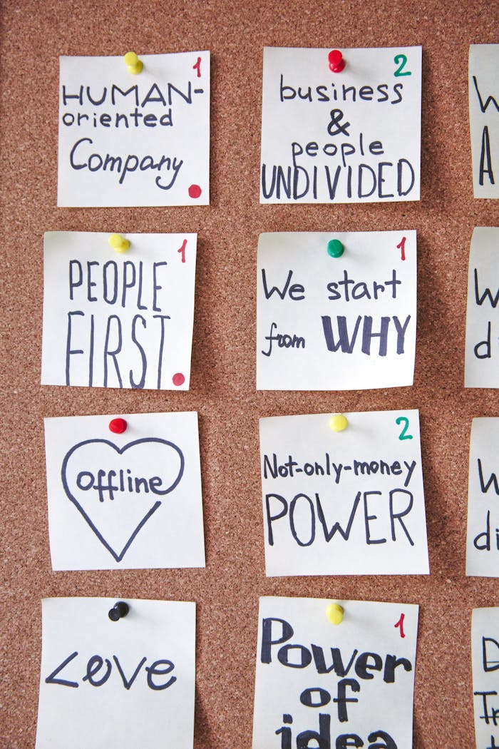 Collection of inspiring handwritten notes pinned on a corkboard to boost business creativity.